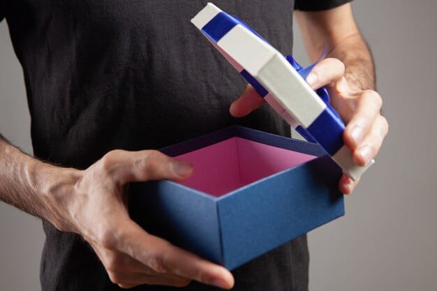 A close-up shot of someone's hands carefully opening a geek subscription box. The focus is on the anticipation and excitement as they reveal the contents. The box is surrounded by other geeky items and merchandise.