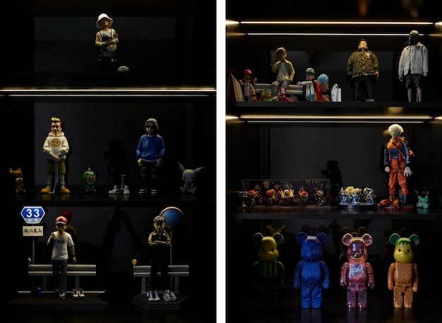 A close-up of a well-organized shelving unit displaying a variety of collectibles, including action figures, statues, and memorabilia, illuminated by soft LED lighting.