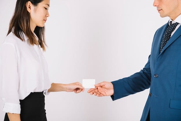 Two businesspeople exchanging business cards. One person is Korean and is receiving the card with both hands.