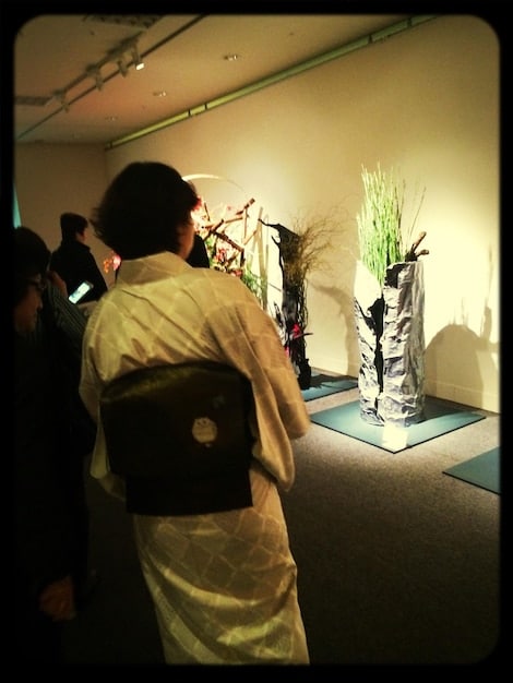 An interior shot of the San Francisco Asian Art Museum's Korean art section, with visitors admiring a display of celadon pottery and Buddhist sculptures, demonstrating interaction with the exhibit.