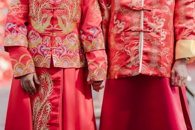 Close-up of a bride and groom in traditional Korean Hanboks, with intricate embroidery details visible on their sleeves and collars, during the Pyebaek ceremony, holding a dates and chestnuts filled cloth.