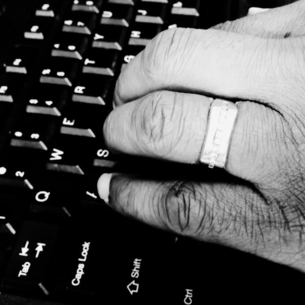 A close-up shot of a composer's hands on a keyboard, with a computer screen displaying music notation software in the background. The focus should be on the composer's hands and the illuminated keys, conveying the technical skill and artistry involved in creating video game music.
