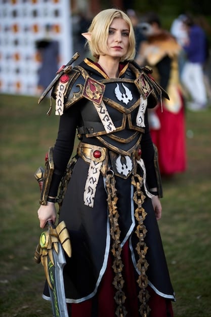A cosplayer on stage at a cosplay competition, showcasing their intricate armor and prop design while performing a character-specific pose. Judges are observing attentively, and the audience is cheering in the background.