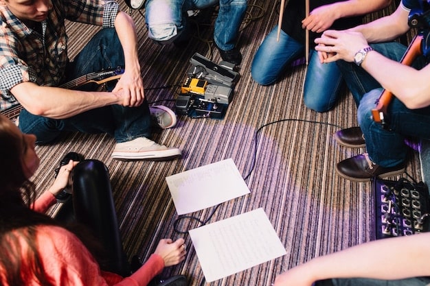 A workshop session with people gathered around a table, working on electronic projects with tools and components visible. The setting is a maker space environment filled with computers, 3D printers, and other equipment.