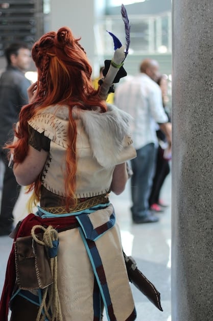 A close-up shot of a cosplayer meticulously crafting a piece of armor for their costume. The focus is on their hands and the tools they're using, showcasing the level of detail and precision involved in creating a high-quality cosplay.