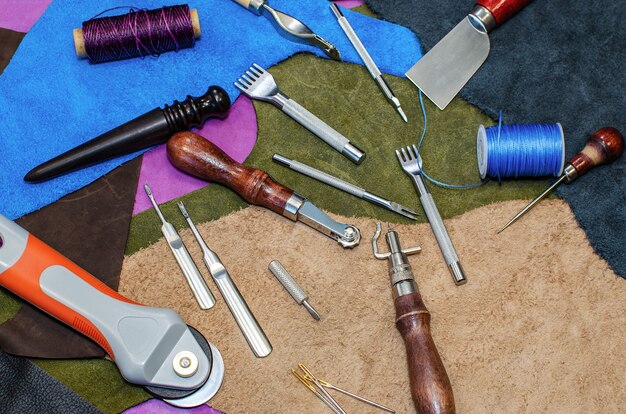A collection of various cosplay crafting tools and materials, including sewing machines, EVA foam sheets, paintbrushes, thermoplastics, and 3D printed parts, showcasing the diverse resources utilized in cosplay creation.