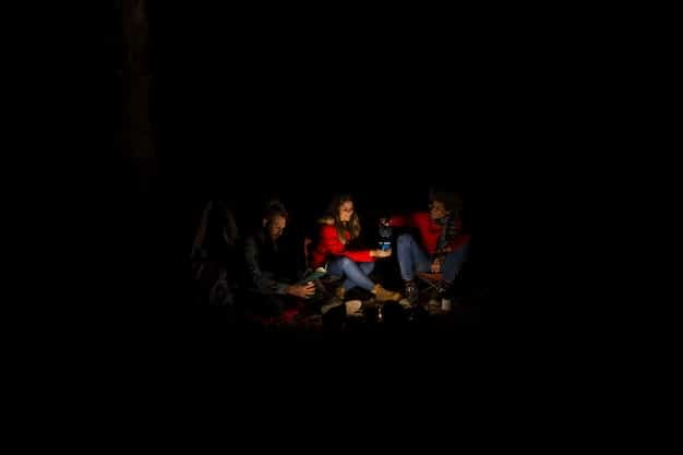 A dimly lit scene depicting players huddled around a table, intensely focused on a 