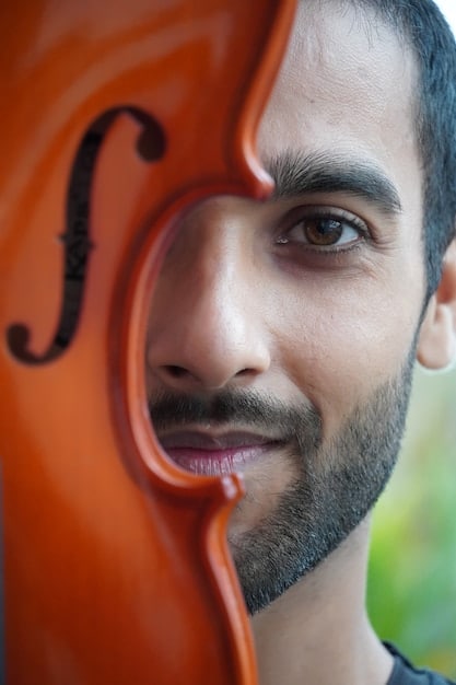 A close-up portrait of Austin Wintory, capturing his thoughtful and artistic expression, possibly with a musical instrument or sheet music subtly included in the background.