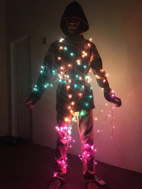 A cosplayer wearing an elaborate costume with integrated LED lights, creating a vibrant and futuristic effect. The lights are strategically placed to highlight key details of the costume and enhance its overall visual impact.