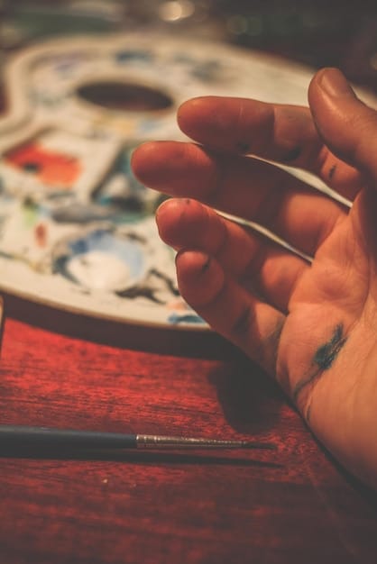A close-up shot of a person's hands meticulously painting a miniature figure for a tabletop game. The lighting is focused on the miniature, highlighting the detail and precision involved.