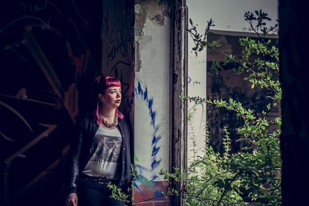 A cosplay photograph showing a cosplayer dressed as a futuristic cyborg character standing in front of a graffiti-covered wall in an urban alleyway.