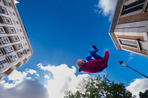 A photographer crouching down with his camera, getting a low angle shot of a cosplayer dressed as Spider-Man, who is posed on top of a building with a cityscape backdrop.