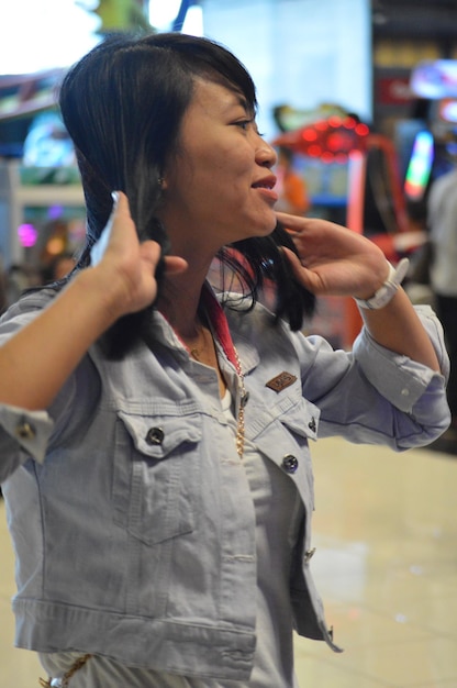 A detailed close-up of a vocal coach guiding a young K-Pop trainee through a breathing exercise, emphasizing proper posture and diaphragm control, with sheet music and vocal training materials visible in the background.
