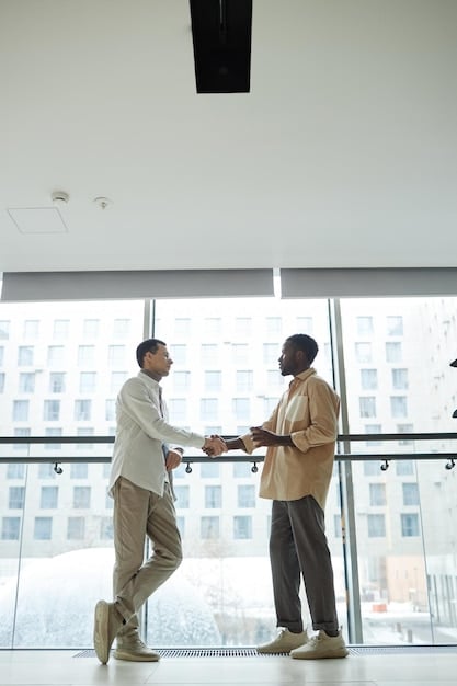 A young American professional shaking hands with a senior Korean executive in a modern office setting. Both are smiling, and the American is bowing slightly to show respect. The scene is well-lit and portrays a successful business interaction facilitated by understanding cultural nuances.