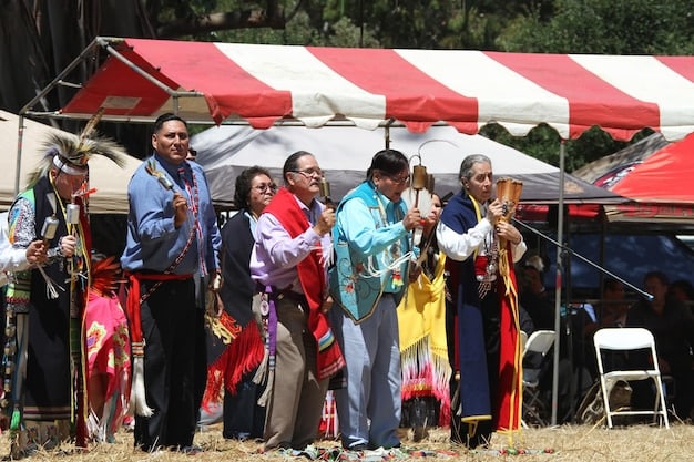 A diverse group of people trying on hanboks at a Korean cultural festival in the US. The scene should be colorful and lively, with a mix of traditional and modern hanboks on display.