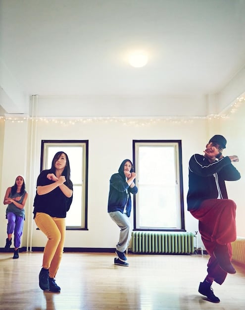 A montage showing trainees in a K-Pop entertainment company practicing dance routines, vocal exercises, and language lessons, highlighting the intensive and multifaceted training process they undergo.