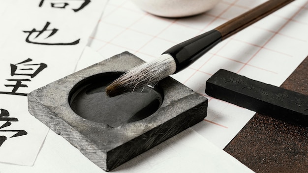 A detailed shot focusing on Korean calligraphy tools, including a brush, ink stick, ink stone, and Hanji paper. The light highlights the textures of each material, demonstrating their unique qualities.