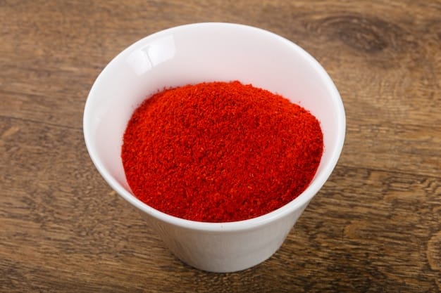 Close-up shot of a bowl filled with bright red gochugaru (Korean chili powder). The texture of the chili powder is visible, and the background is blurred to highlight the ingredient.