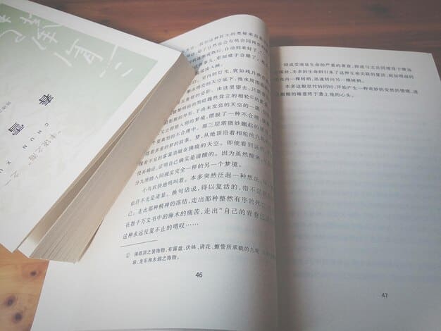 A close-up shot of a Korean language textbook open to a page explaining honorifics. The text is a mix of Korean characters and English translations, with key terms highlighted. A hand points to a specific honorific, emphasizing its importance and usage.