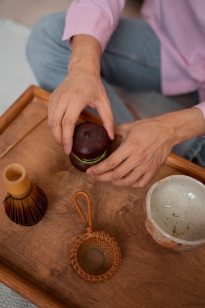 A close-up shot of hands meticulously arranging traditional Korean teaware in preparation for a tea ceremony. The teaware includes a small teapot, several teacups, a cha seon (tea scoop), and other implements, all set on a beautifully textured wooden tray. The background is blurred to focus attention on the hands and teaware, highlighting the care and precision involved in the ritual.]