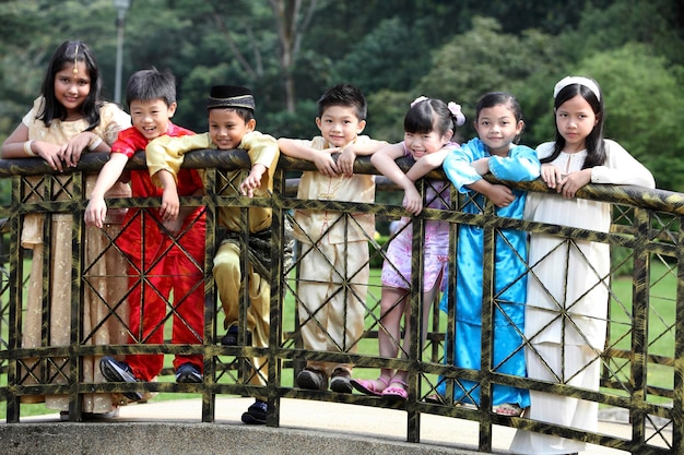A group of Korean-American children dressed in colorful hanboks are shown performing a traditional Seollal bow (sebae) to their grandparents. The scene takes place in a modern American living room adorned with Korean decorations.