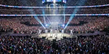 Energetic K-Pop concert in a US arena with thousands of fans and lightsticks.